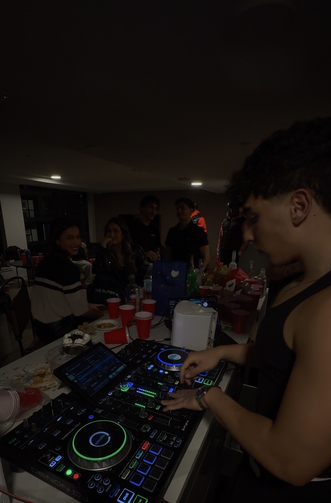 DJ performing beside guests at a private celebration