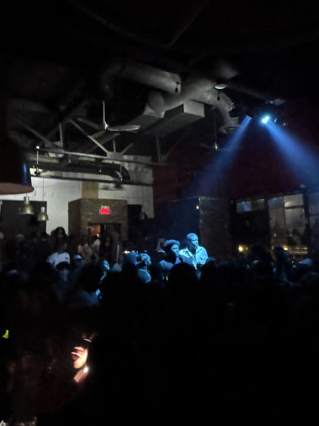 Crowd facing the DJ booth under blue lighting